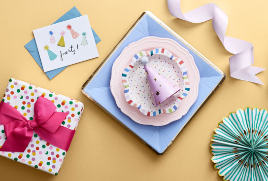 An assortment of party supplies, cards, ribbons & gift boxes.